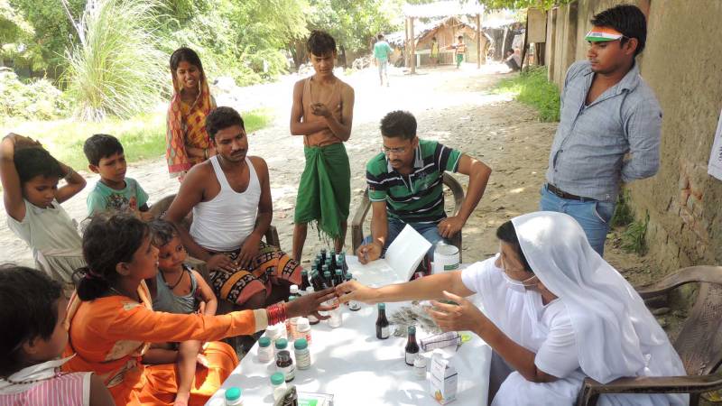 maji distributing ayurveda medicine to people